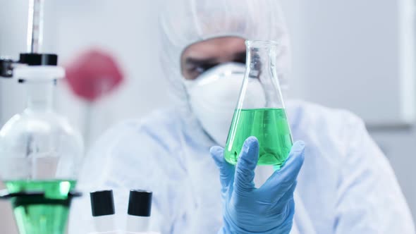 Biotechnologist Looking at a Sample with Green Liquid