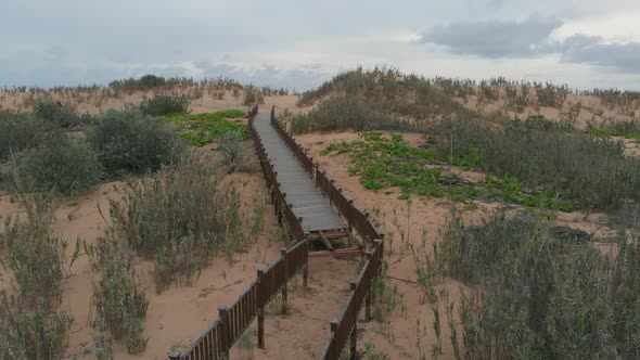 Walkway to Matadouro Beach with inaccessible from main entrance . Aerial forward ascending