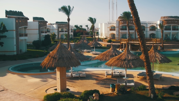 Sunny Hotel Resort with Blue Pool, Palm Trees and Sunbeds in Egypt