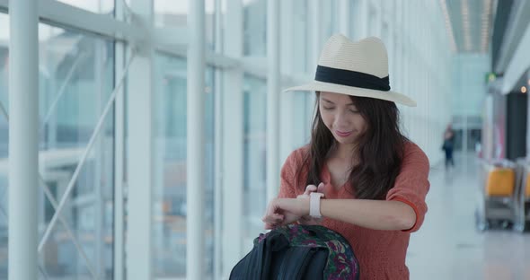 Woman check the time on the smart watch in the airport