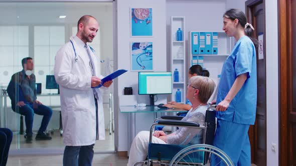 Doctor Checking Diagnosis of Disabled Senior Woman