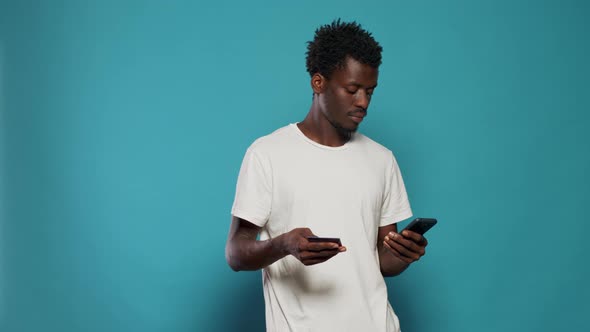 Young Man Using Credit Card for Online Shopping on Smartphone