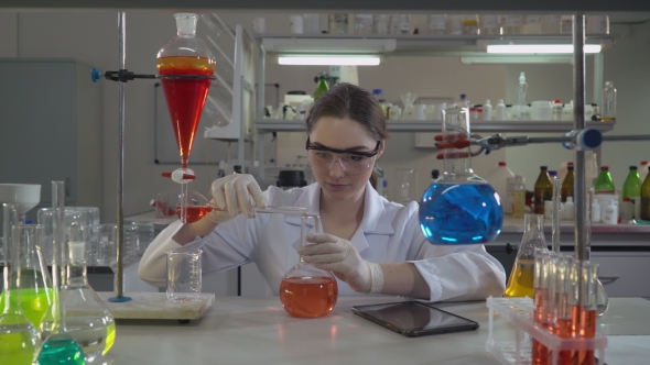 Professional Scientist Pouring Liquid To Glass Bulb