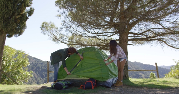 Couple Setting Tent Under Trees