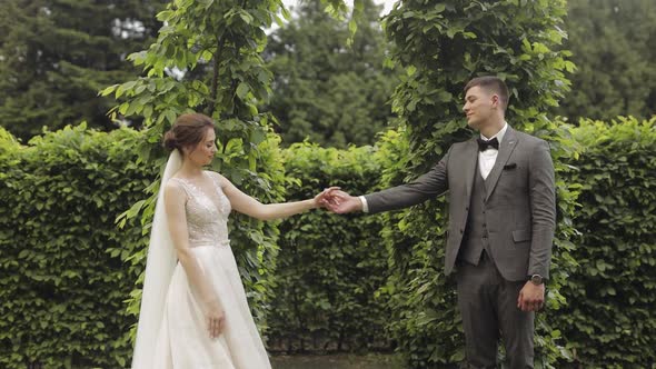 Newlyweds Caucasian Groom with Bride Walking Embracing Hugs in Park Wedding Couple
