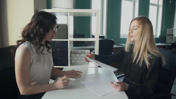 In the Office, Two Women at the Desk Exchange Important Documents