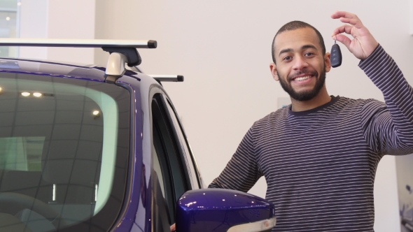 Man Stands Near the Purple Crossover at the Showroom