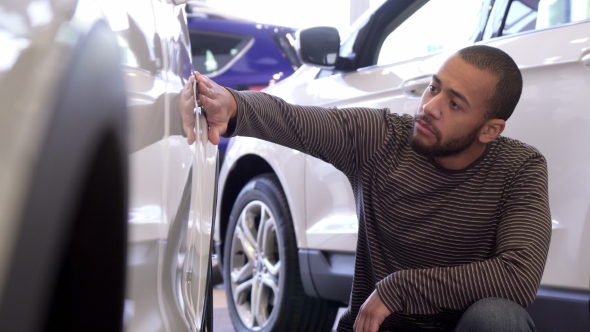 Man Touches Car Wing at the Dealership