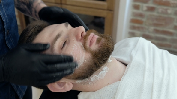 Hairdresser Covering Face of Client with Towel. Man Visiting Barber Shop.