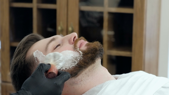 Client During Beard Shaving in Barber Shop