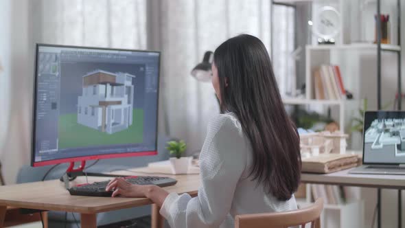 Asian Woman Engineer Rotate 3D House While Working On A Desktop At Home