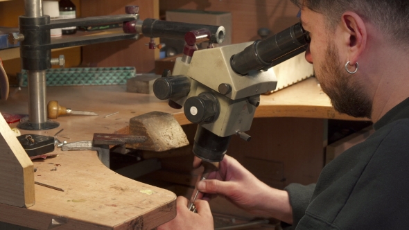 Jeweler Looks Through the Microscope