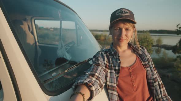 Portrait of Young Pretty Woman Standing by Van at Lakeside