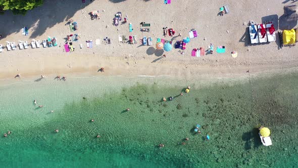 Aerial top down view of people swimming in sea, relaxing at the beach