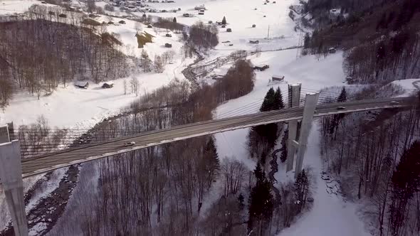 Drone flies to the bridge and tilts top down.