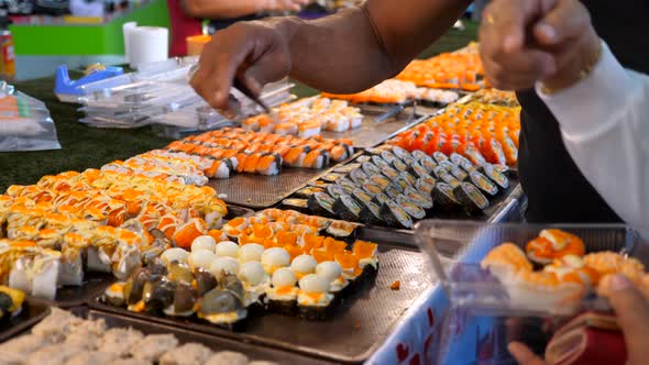 Man and Woman Choosing Fresh Sushi Set From Night Market