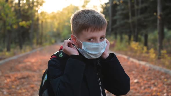 Child Boy Takes Off His Medical Mask Outdoors