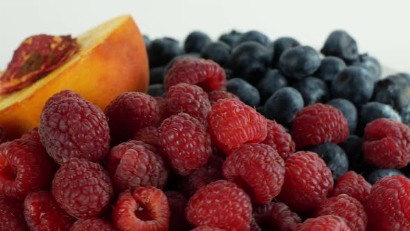 Assorted fruits and berries on a white background rotation 360. Summer fruit raspberry peach