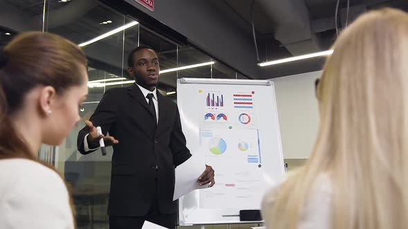 African American Businessman Explaining Project Graph During Flip Chart Presentation for Considerate