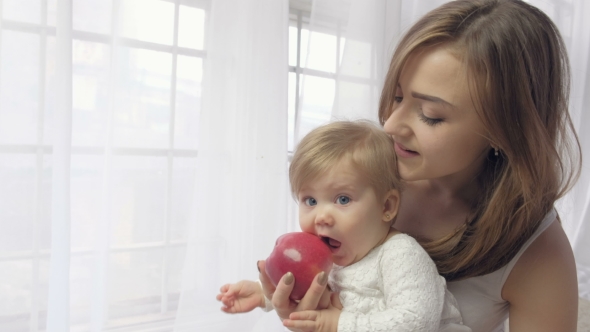 Mother Holding Baby with Apple