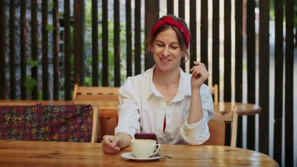 Happy Girl Talking on Video Call Via Phone or Watching Video in Street Cafe Easy Lifestyle and