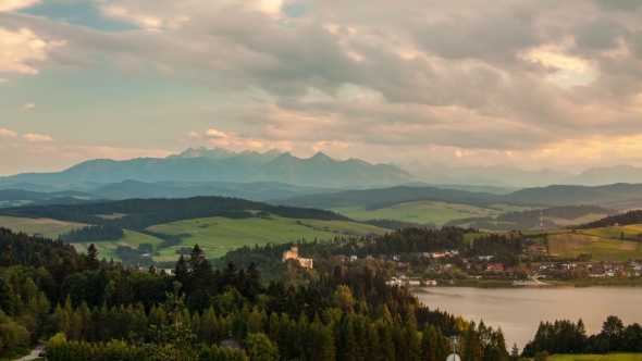 Sunset and Clouds Over Mountains and Lake with Village