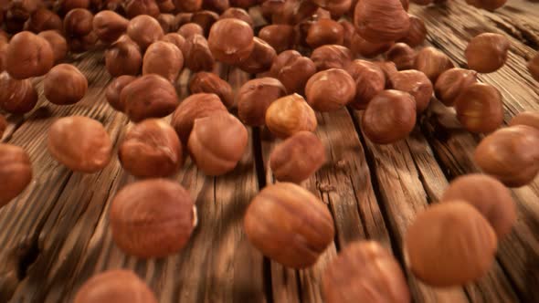 Super Slow Motion Detail Shot of Hazelnuts Rolling Towards on Wooden Background at 1000Fps