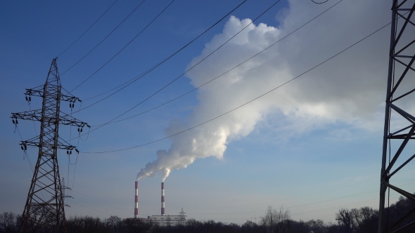 Power Lines and Pipe Smoke Power Plant Against Blue Sky.