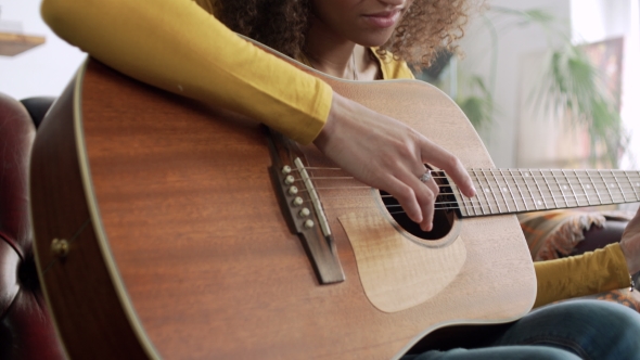 Inspired Happy Young Beautiful Latin Woman Play Melody on Acoustic Guitar and Beat Rhythm