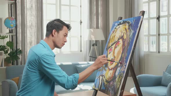 Asian Artist Man Coming To Sit Down And Painting A Girl's Hair On The Canvas