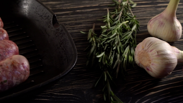 Raw Sausages with Garlic, Rosemary on Wooden Surface