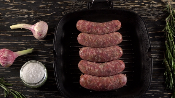 Raw Sausages with Garlic, Rosemary on Wooden Surface