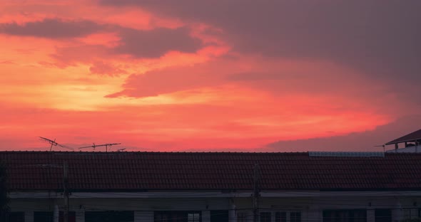 Beautiful fiery sunset over the roofs of houses - zoom
