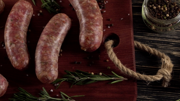 Raw Sausages with Garlic, Rosemary on Wooden Surface