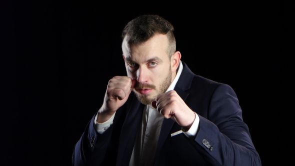 Sportsman in Business Suit Is Boxing, Looks at the Camera