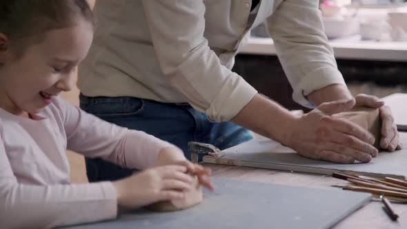 Small Child Girl with Adult Father Making Earthenware Objects in