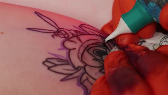 Tattoo Artist Makes a Tattoo Woman on a Arm, Works in Studio in Red Light. Slow Motion Close View