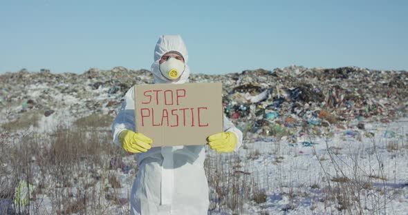 Man Wore in Protective Suit Show Protest Sign "Stop Plastic" at Plastic Landfill