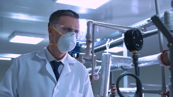 Scientist Writing in Journal While Standing in Lab alt