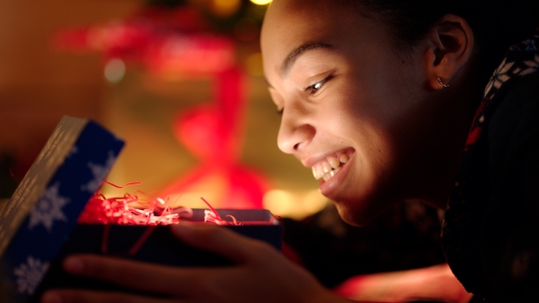 Portrait of Teen Girl Is Openning Gift and Her Face Is Shining with Light