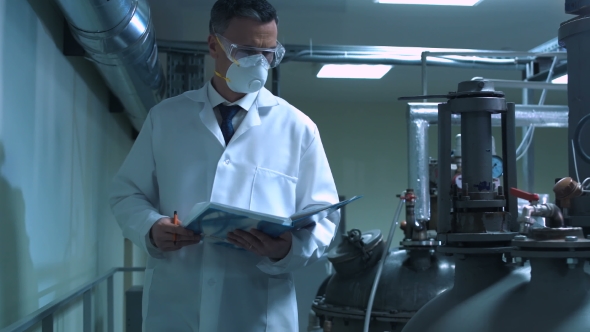 Scientist Writing in Journal While Standing in Lab alt