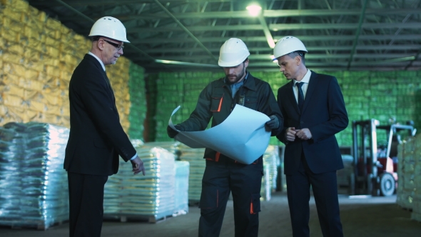 People in Warehouse with Blueprint
