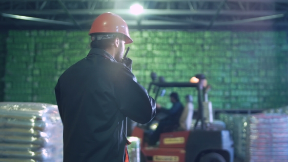 Man Talking Radio Set in Warehouse