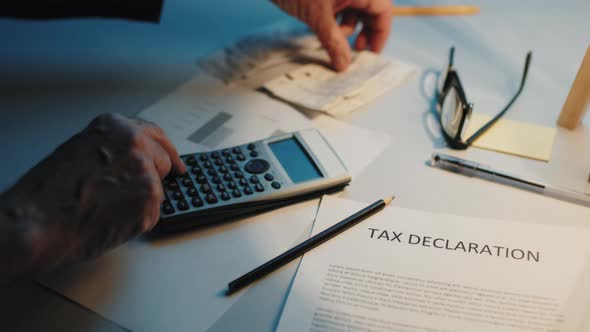 Man is Counting Receipts for Tax Returns