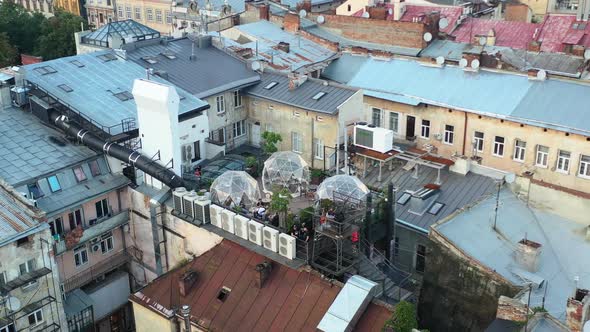 Aerial drone of a rooftop bubble restaurant in Lviv Ukraine surrounded by old European buildings