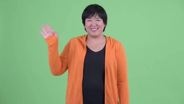 Happy Young Overweight Asian Woman Waving Hand Ready for Gym