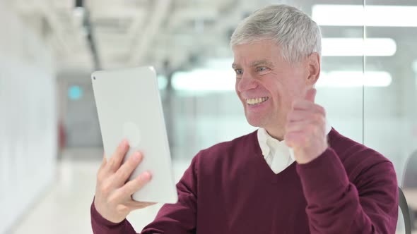 Middle Aged Man Celebrating Success on Tablet 