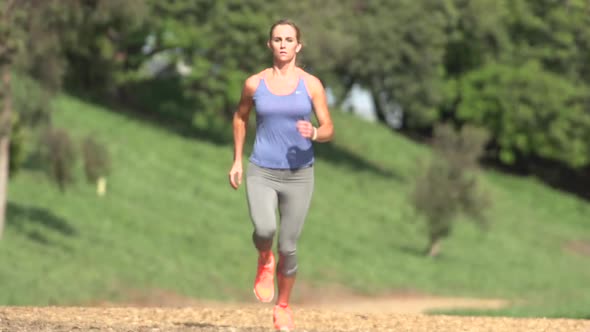 A woman running on a wood chip trail