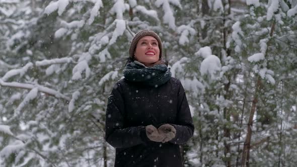 Attractive Female in Winter Forest Catches Snowflakes and is Really Enjoying It