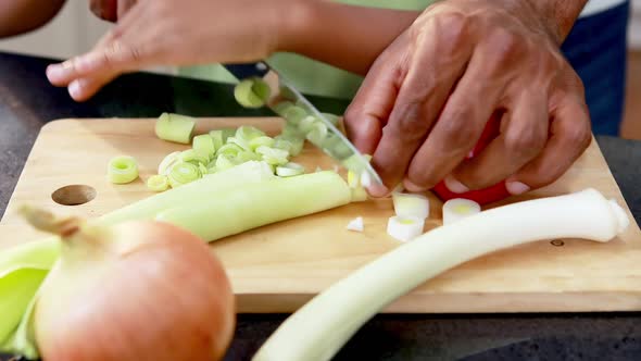 Father assisting son to cut vegetables 4k